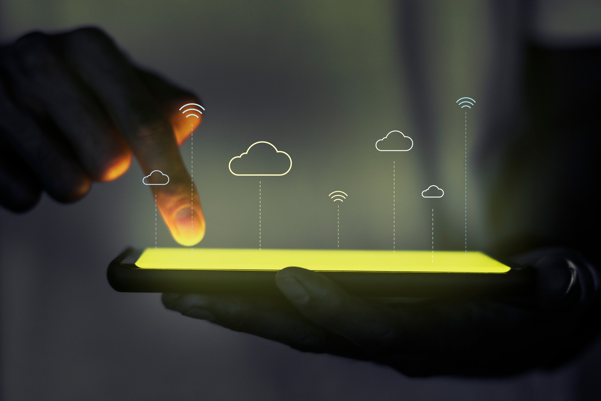 Hand tapping a phone with cloud and connectivity icons floating above it